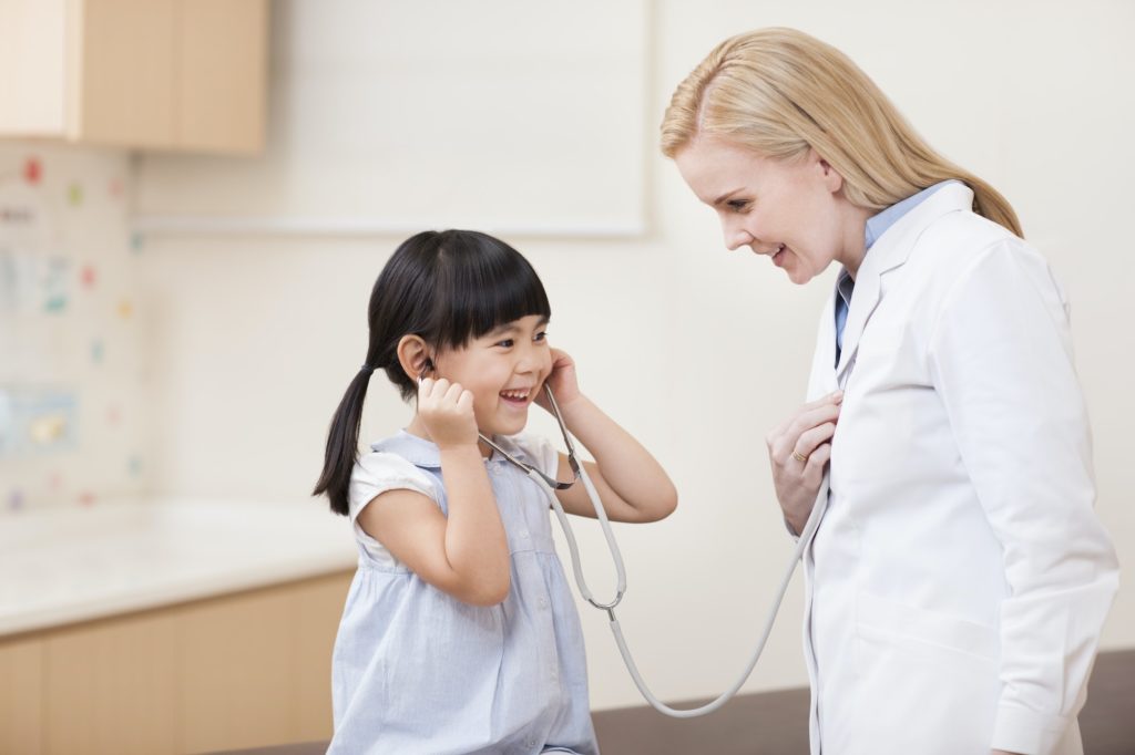 Happy doctor and girl with stethoscope